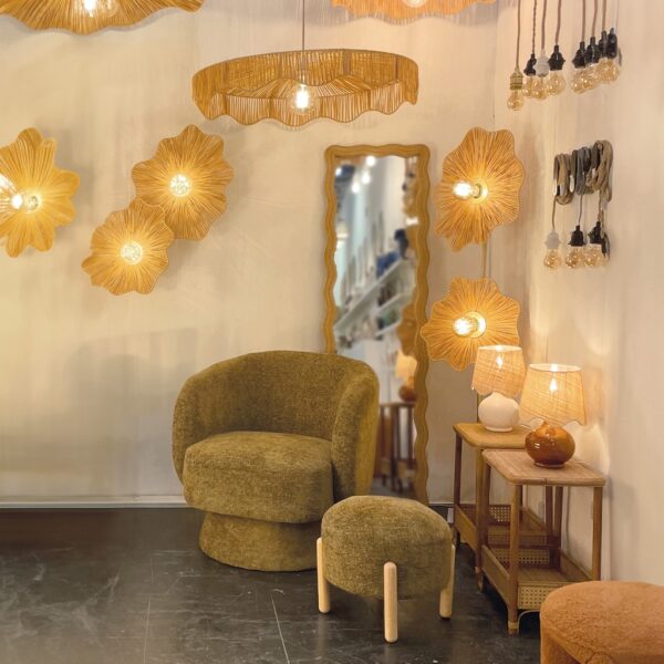 Fauteuil design en tissu chenille vert kaki, au dossier enveloppant et à l’assise généreuse, accompagné d’un repose-pieds assorti dans un intérieur chaleureux à l’esprit naturel et raffiné